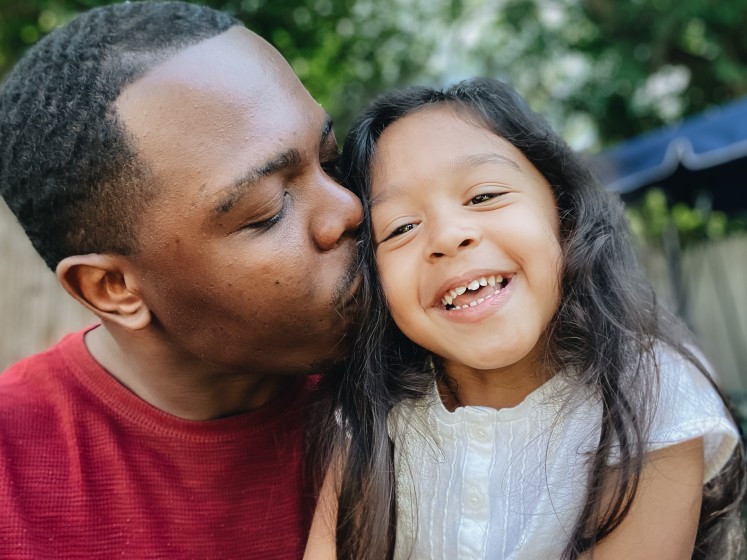 Dad kissing daughter on the cheek