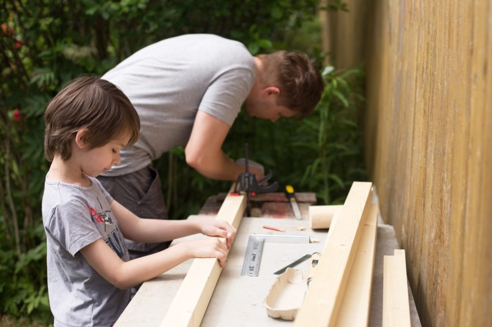 Boy helping dad do woodwork